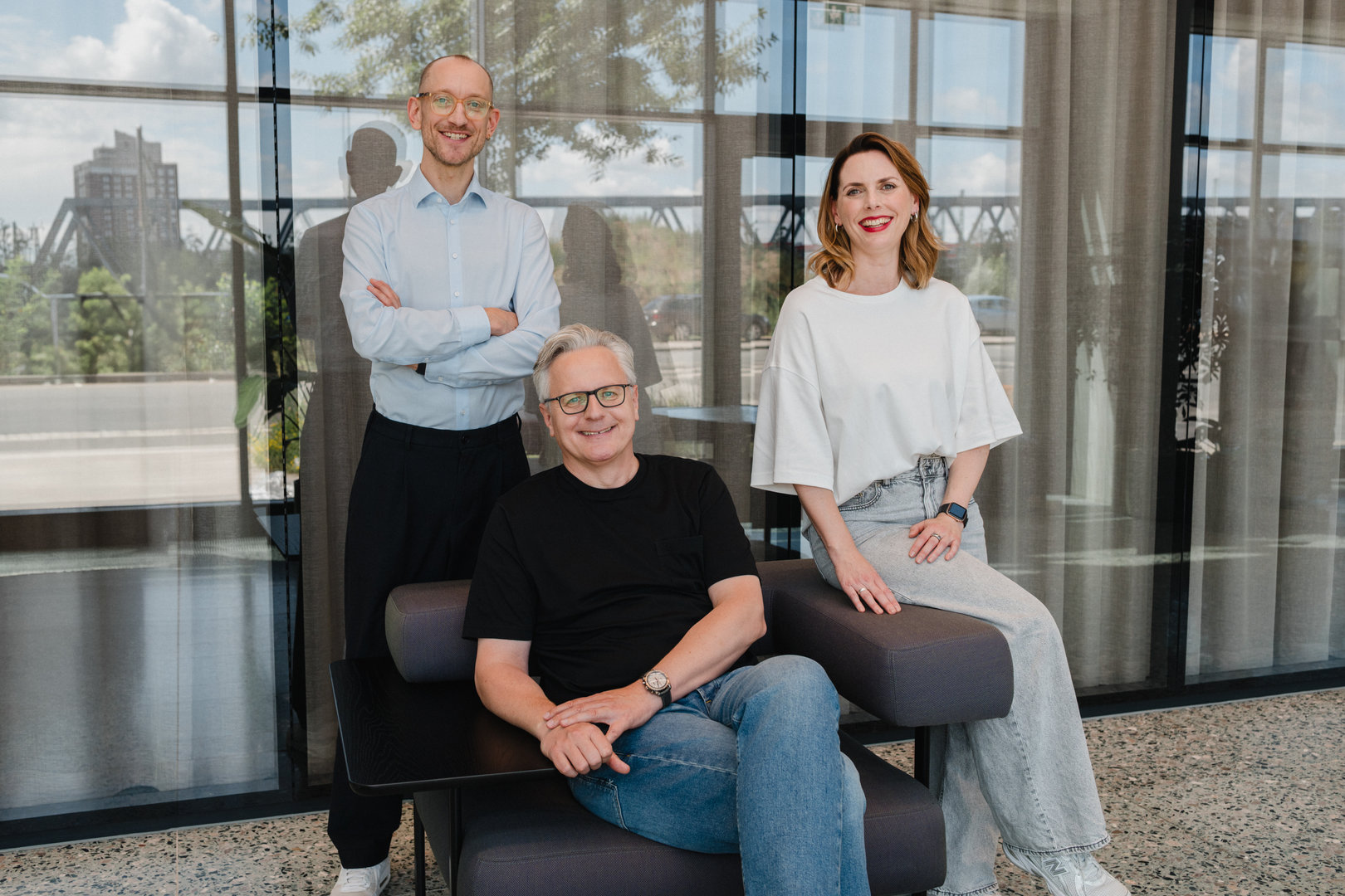 Gründerteam von Experience Media in moderner Glasarchitektur